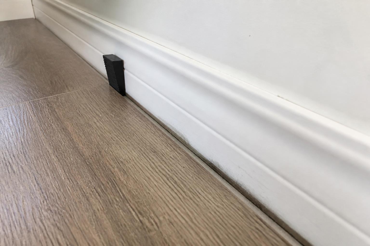 Close-up of an expansion gap left along the wall edge during laminate flooring installation