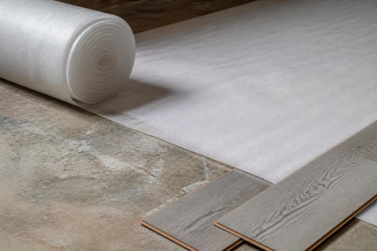 Underlayment being rolled out under SPC vinyl plank flooring for sound dampening