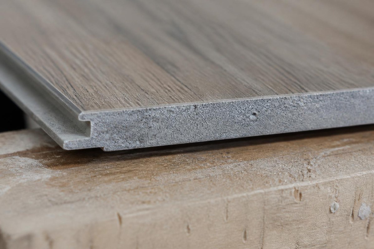 Close-up of rigid-core SPC vinyl plank cross-section showing the stone-composite core layer